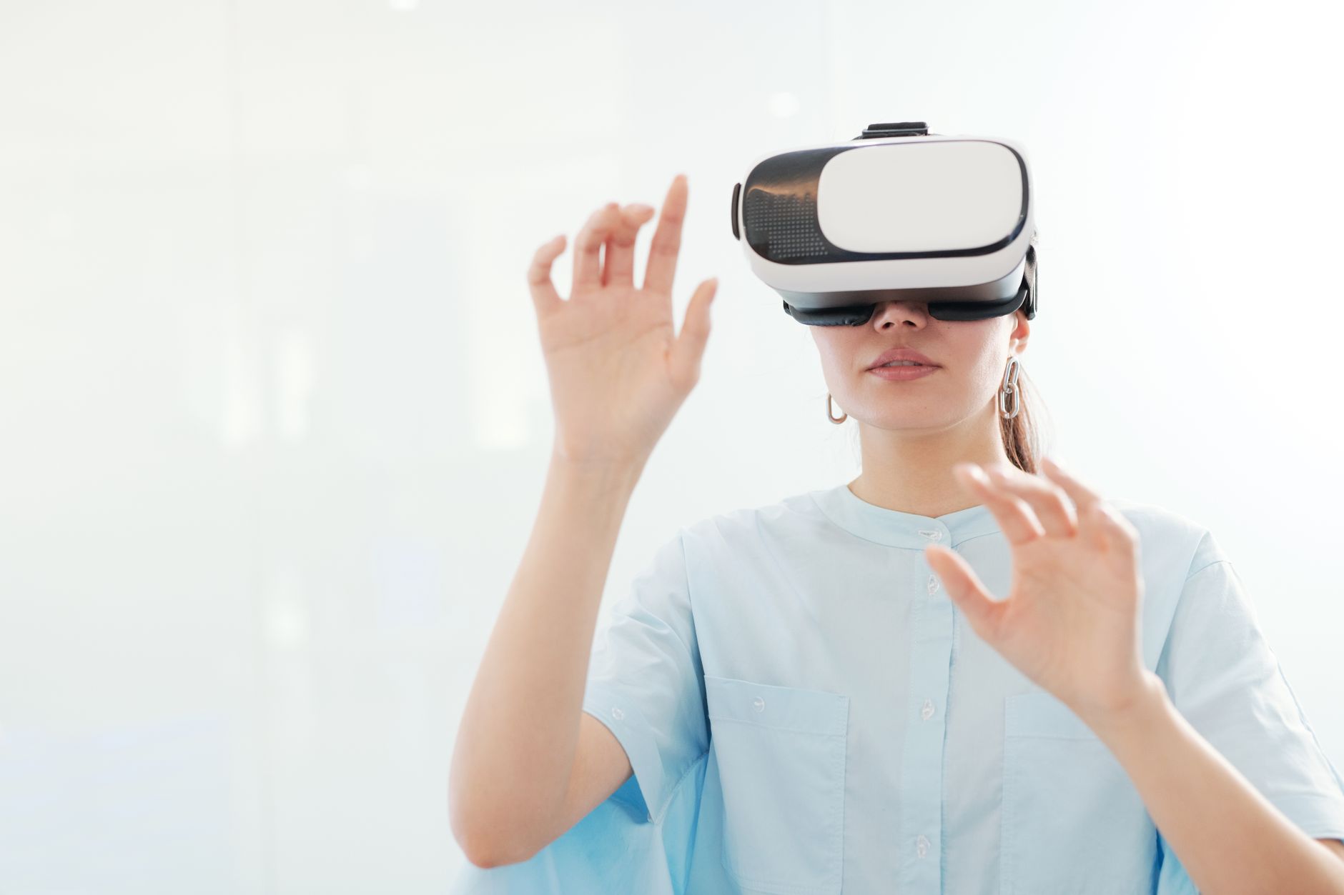 VR/ARヘッドセットを装着した女性が手を伸ばして操作している様子